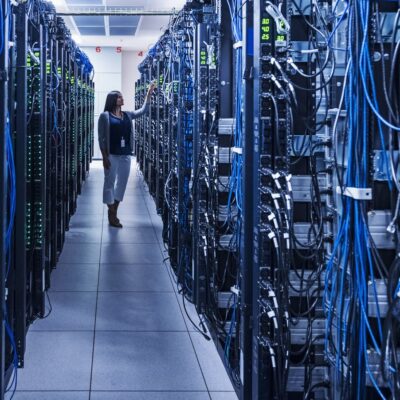 A woman stands in a server room.